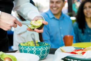 Scoop out the avocado with a spoon and add it to the bowl in sliced and diced pieces.