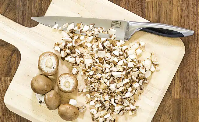 Chop the mushrooms by hand with a knife for the Farr Better Vegan Cream of Mushroom Soup